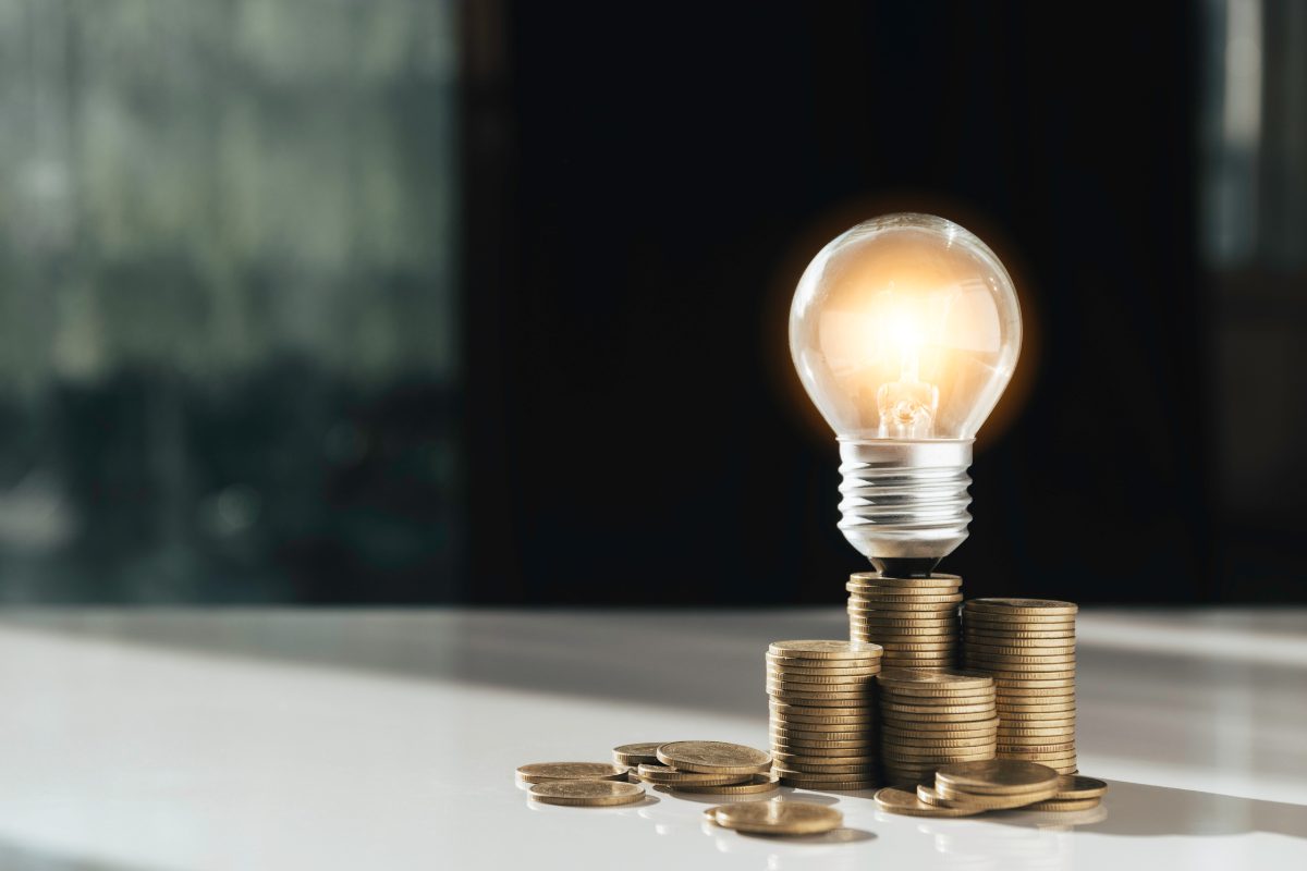 Coins and light bulb put on the table for saving money,energy concept.