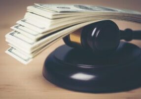 Concept of Legal court gavel on assorted cash, Close up.