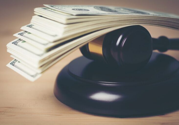 Concept of Legal court gavel on assorted cash, Close up.