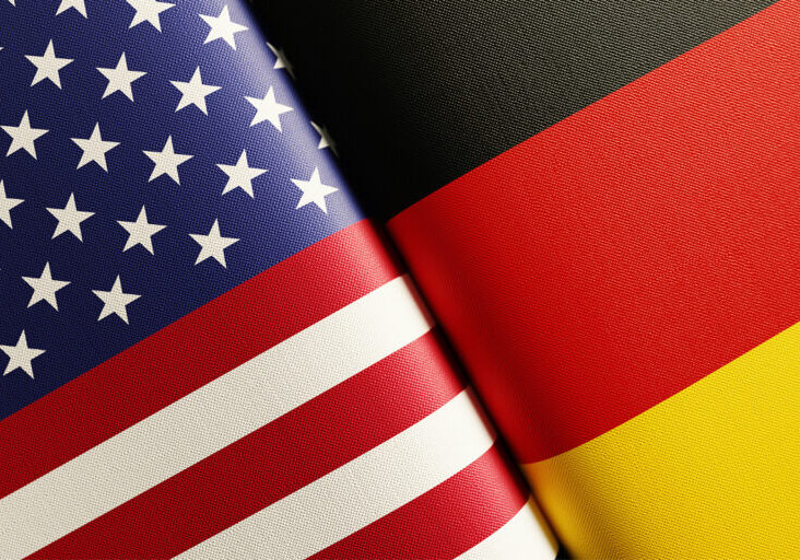 American and German flag pair. Horizontal composition with copy space and selective focus