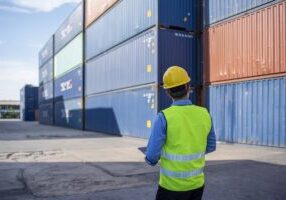 Foreman control loading Containers box from Cargo freight ship for import export.