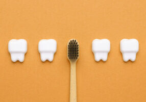 teeth and toothbrush on an orange background