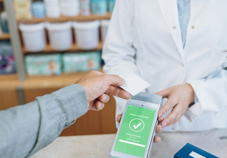 Pharmacist working in pharmacy and serving customer, checking supplies using technologies