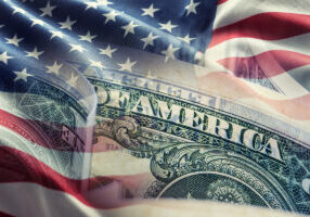 American flag and dollar banknotes - business background.