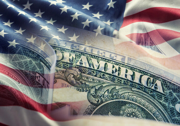 American flag and dollar banknotes - business background.