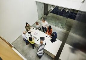 Wide high angle shot businesswoman leading project meeting in office