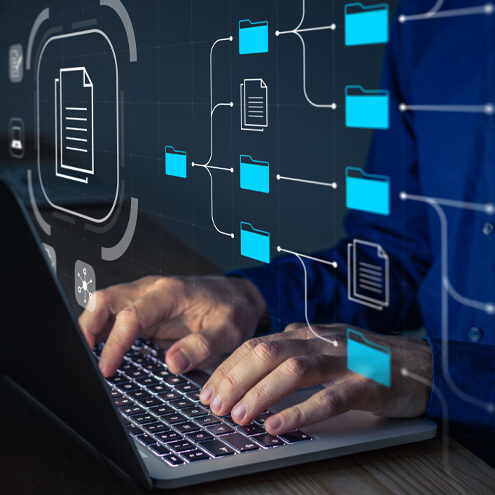 Document Management System (DMS) being setup by IT consultant working on laptop computer in office.