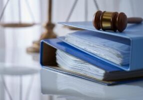 Gavel hammer on stack of document libra scale as background