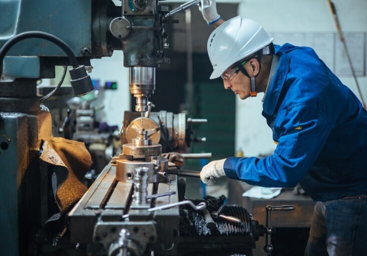 Asian male engineer working on lathe