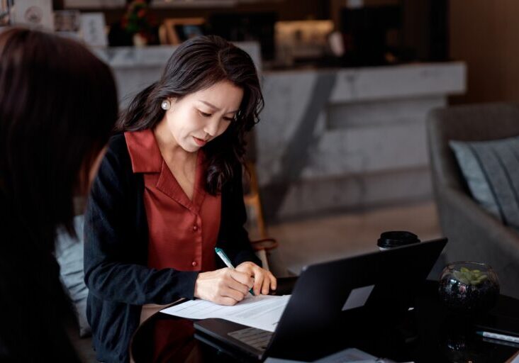 Business Leader Signing Documents During Discussion