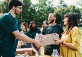 A couple is taking a donation box at the food and clothes bank