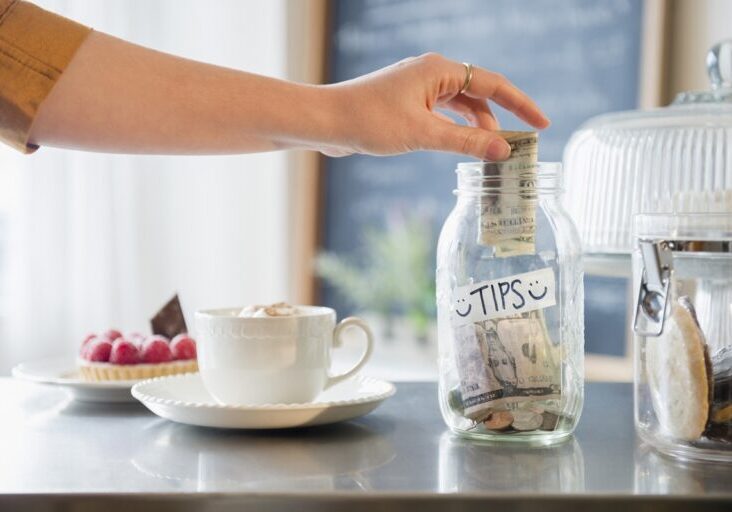 Caucasian woman putting money in tip jar