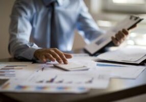 Business accounting concept, Business man using calculator with computer laptop, budget and loan paper in office.