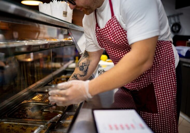 Fast food kitchen worker at the kitchen counter with gloves