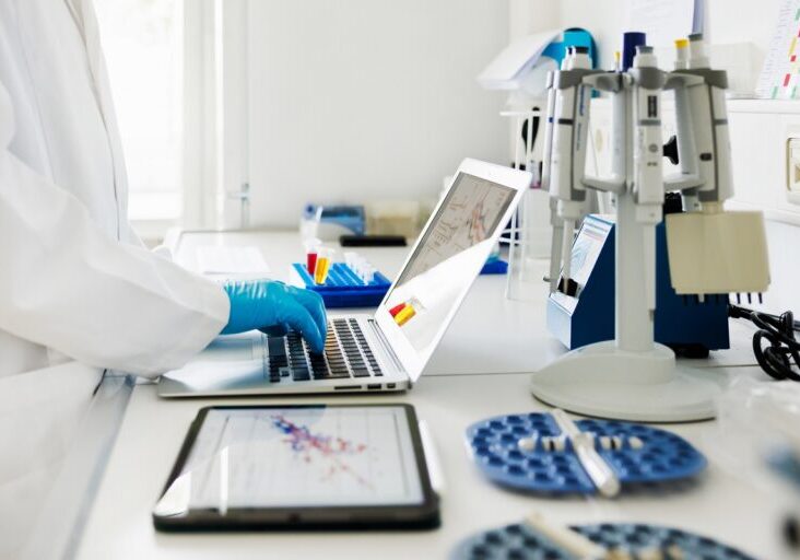 Close-Up Shot of Scientists Hands typing Data in Laptop in Laboratory