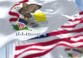 The Illinois state flag waving along with the national flag of the United States of America