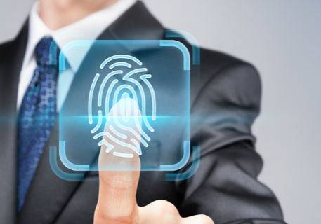 Suited man placing index finger on a print scanner