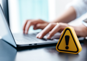 Warning sign placed on a table while a businesswoman works