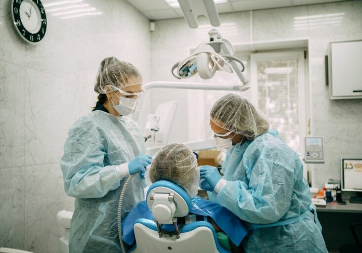 Orthodontist doing professional cleaning of female patient's braces