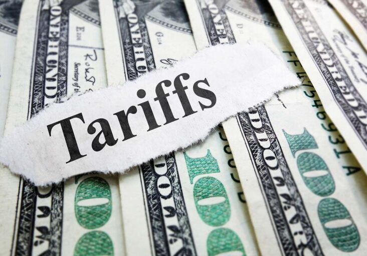Tariffs newspaper headline on money - stock photo