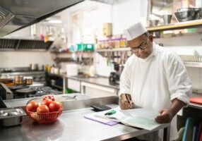A chef is balancing the accounts in the kitchen