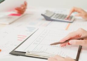 Closeup group of Asian business people meeting discuss project plan and financial results in office. Marketing strategy analysis, stock market trading, financial consultant concept.
