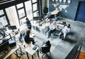 Coworkers having informal project meeting in high tech office overhead view