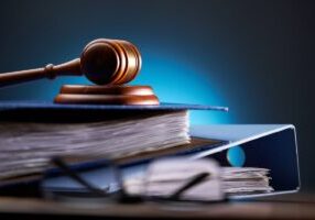 Close-up of gavel on books against black background