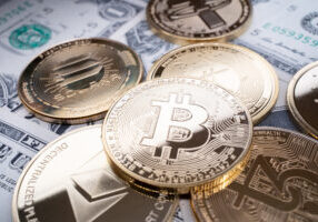 Several different digital coins (BTC) (USDT) (ETH) (ADA) (XTZ) on US currency banknotes