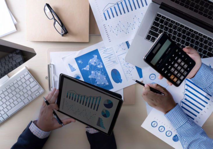 Two people holding a tablet and calculator